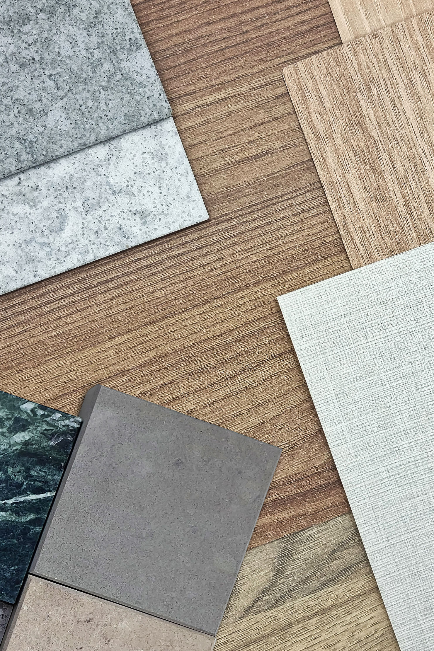 interior material board containing multi pattern of wooden laminateds, grainy quartz stones, grey interior fabric wallpaper, green marble, artificial stone samples. close up or macro view. mood board.